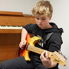 Dreng spiller el-guitar